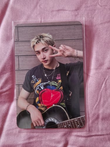 Customer's Stray Kids photocard featuring Bang Chan playing an acoustic guitar and making a peace sign