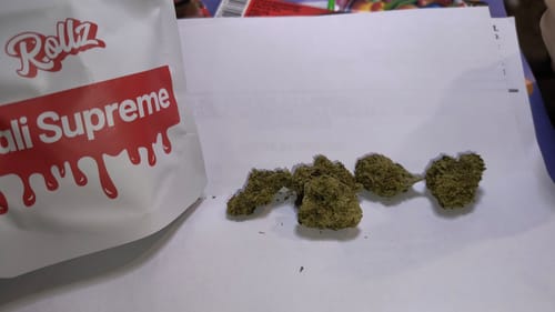 Customer's Rollz Cali Supreme THC-A flower buds next to the product's white and red branded packaging.
