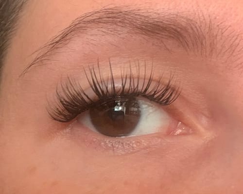 Customer's eyes wearing THE VANILLA GIRL wimpernextensions, showcasing a long, natural, and curved dark lash look.