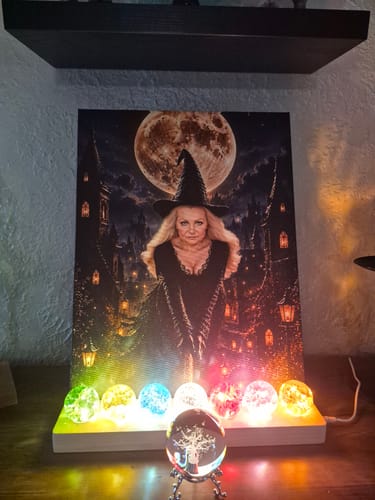 Customer's Moonlit Enchantress Flight portrait displayed on a lit stand, glowing with vibrant, colorful lights.