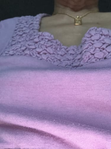 Customer's gold-plated The Sun Tarot pendant necklace worn around the neck.