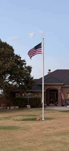 Customer's 20 ft. Commercial Flagpole with an American flag installed in a residential lawn.