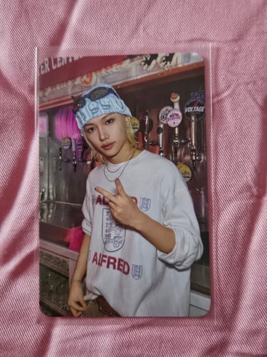 Customer's Stray Kids photocard featuring a person in a light blue beanie and white shirt making a peace sign