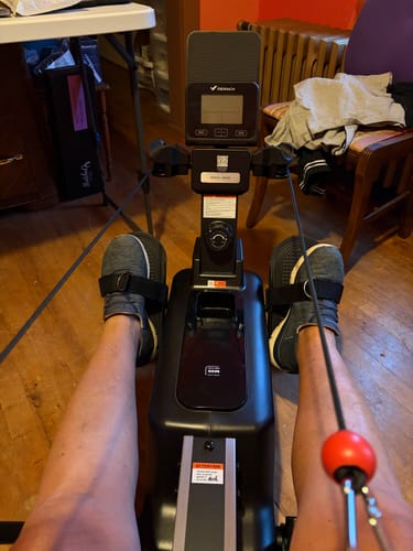 Customer's NovaRow RS3 rowing machine with pedals and handles, viewed from a seated exercise position.