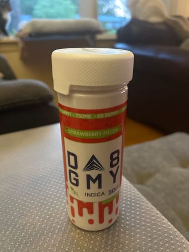Customer's Delta 8 Strawberry Fields gummy jar sitting on a couch, used for relaxation.