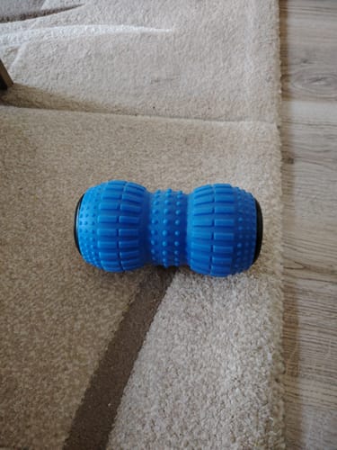 Customer's blue vibrating massage roller placed on a beige carpet.
