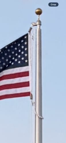 Reviewer's close-up of the 20 ft. Commercial Flagpole hardware, showing the rope halyard and revolving truck.