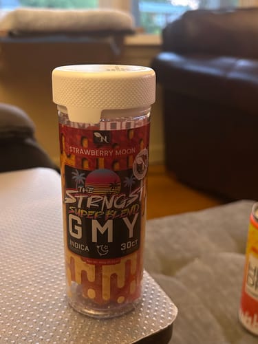 Customer's jar of Strawberry Moon The Strongest GMY Indica gummies sitting on a surface.