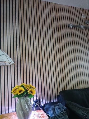Kundens Premium spiler kontaktplast montert på en vegg, som skaper en moderne 3D-effekt bak en vase med solsikker.
