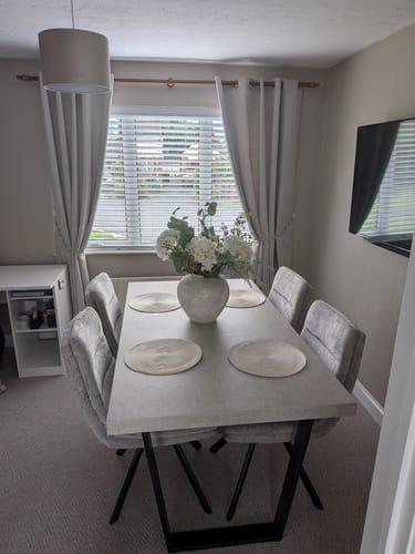 Customer's Arina Vase filled with a large flower arrangement on a light grey dining table.