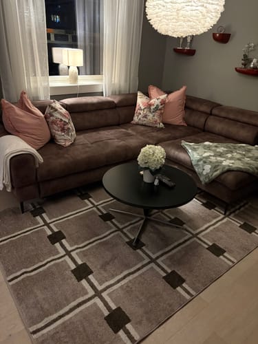 Customer's living room featuring a couch, with the Artisan Oak kontaktplast on a round coffee table in the center.