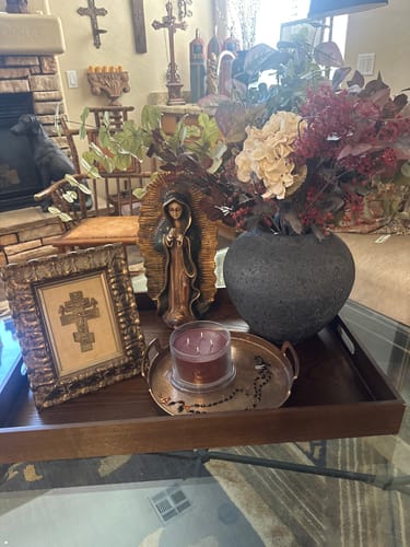 Customer's Faux Arrangement of burgundy berries and hydrangea in a dark vase, displayed on a wooden tray.