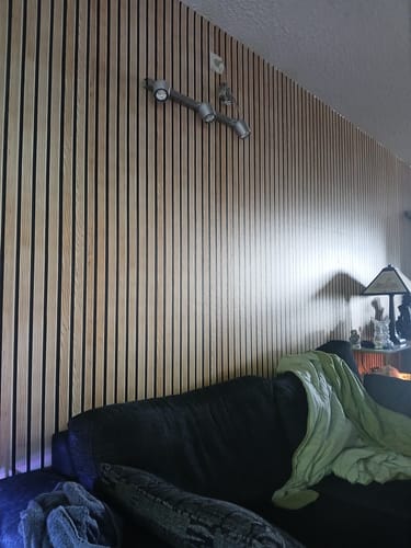 Customer's Premium spiler kontaktplast montert som en fondvegg bak en sofa i en stue.