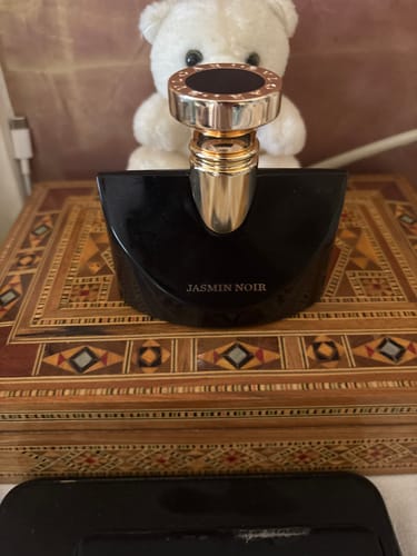Customer's Bvlgari Splendida Jasmin Noir perfume bottle placed on a decorative wooden box with a white teddy bear behind it