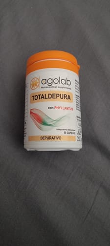 Reviewer's bottle of TotalDepura depurativo detox supplement with orange cap, captured in a close-up shot.
