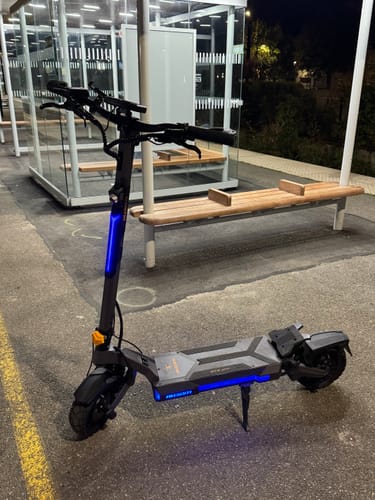 Customer's Ausom DT2 Pro e-scooter parked at night with blue lights on, showing a sturdy, sleek frame.